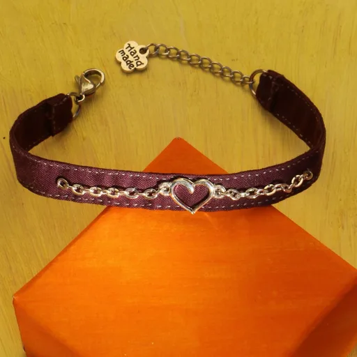 Bracelet en tissu couleur pourpre orné d'une breloque enchaînée en forme de cœur