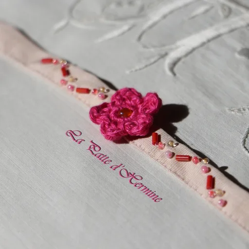 Ras de cou en coton alliant tissu beige uni, fleur en crochet de couleur fuchsia