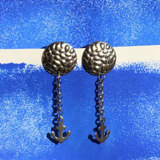 Paire de boucles d’oreilles composées d’une base ronde en acier martelé et d’un 