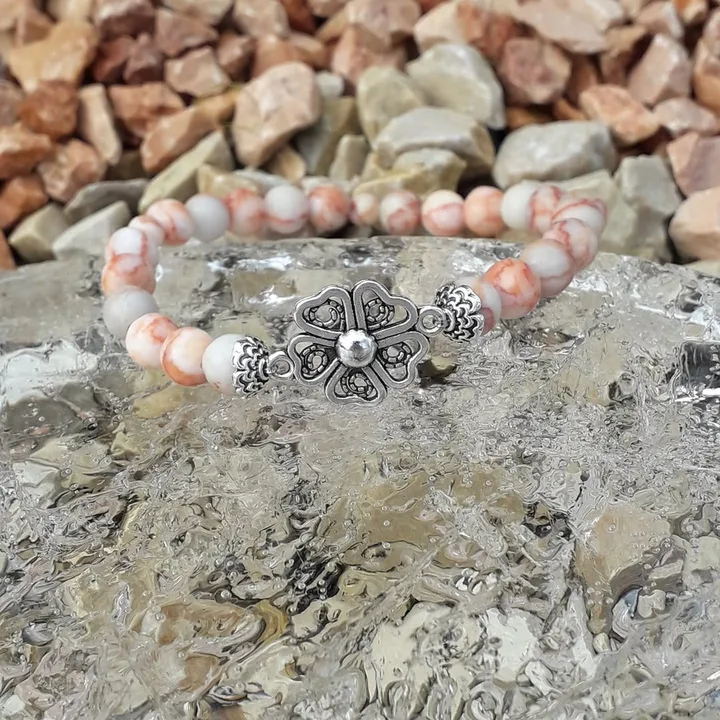 Bracelet élastique en perles de jaspe couleur saumon orné d'une breloque en form