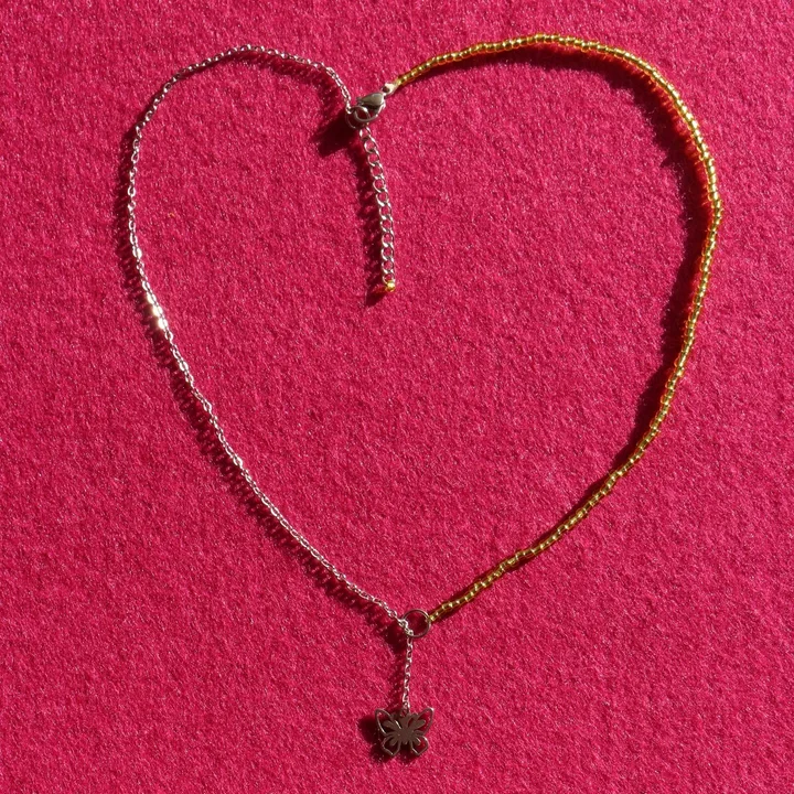 Collier coulissant bi-matière composé d’une chaîne fine ornée d’une breloque en 